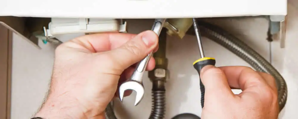 Boiler repair technician tightening pipe fittings and connections in Baltimore, MD