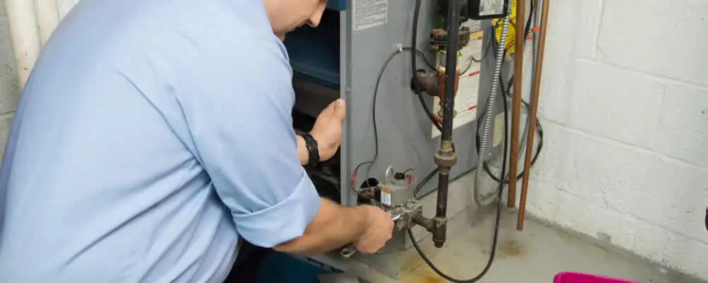 Furnace repair technician inspecting and servicing a home heating system in Baltimore, MD