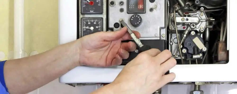 Heating repair technician adjusting boiler controls and components in Baltimore, MD