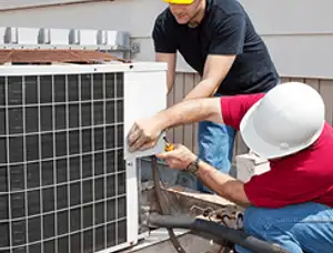 HVAC technicians repairing an outdoor AC unit on a rooftop in Baltimore, MD