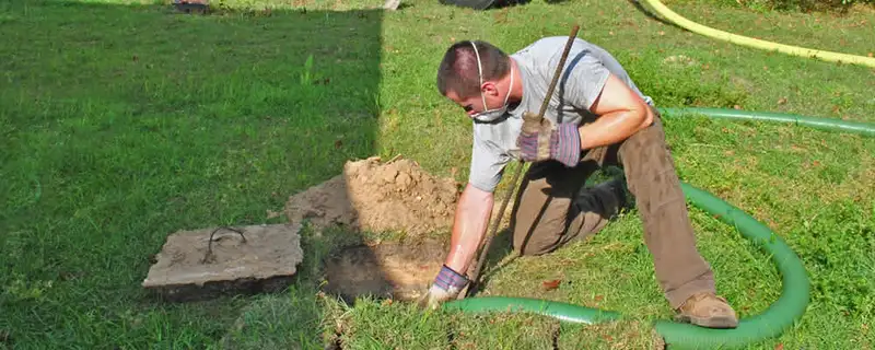 Septic pumping technician servicing a residential septic tank in Baltimore, MD