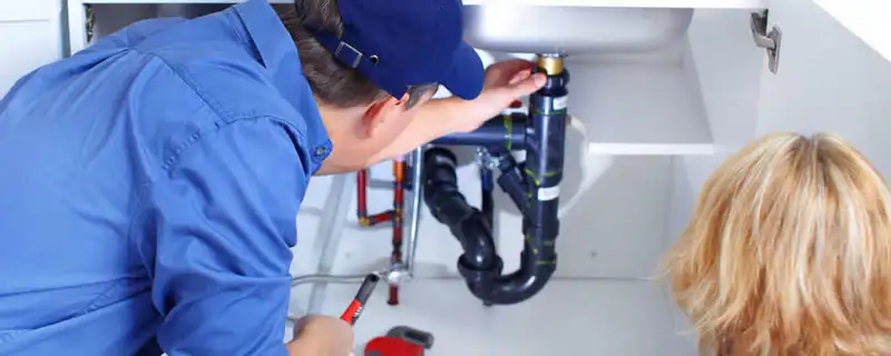 Plumber repairing under-sink drain pipes and fittings in Baltimore, MD